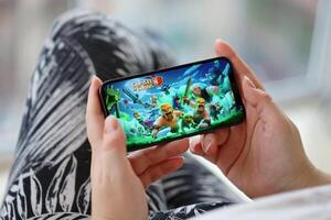 Clash of Clans mobile iOS game on iPhone 15 smartphone screen in female hands during mobile gameplay photo