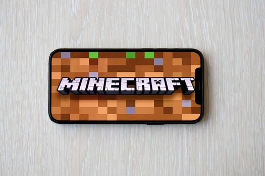 Minecraft mobile iOS game on iPhone 15 smartphone screen on wooden table during mobile gameplay photo