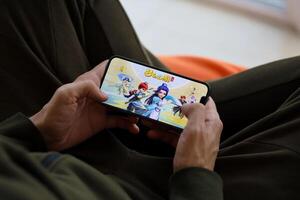 Fantasy Westward Journey mobile iOS game on iPhone 15 smartphone screen in male hands during mobile gameplay photo