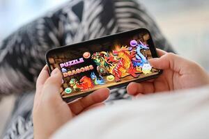Puzzle and dragons mobile iOS game on iPhone 15 smartphone screen in female hands during mobile gameplay photo