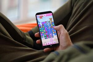 Candy Crush Saga mobile iOS game on iPhone 15 smartphone screen in male hands during mobile gameplay photo