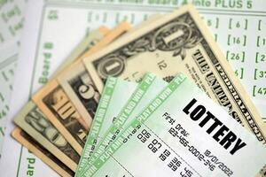 Green lottery tickets and US money bills on blank with numbers for playing lottery photo