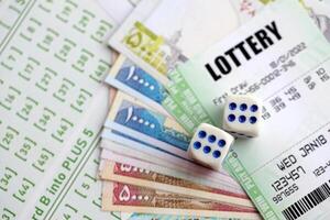 Green lottery tickets and iranian money bills on blank with numbers for playing lottery photo