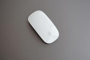 KYIV, UKRAINE - NOVEMBER 27, 2023 Apple Magic Mouse 3rd generation lies with grey MacBook 2021 photo