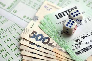 Green lottery tickets and ukrainian money bills on blank with numbers for playing lottery photo