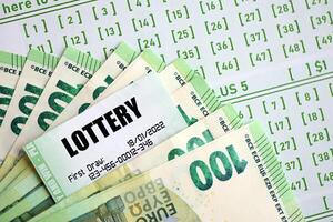 Green lottery tickets and euro money bills on blank with numbers for playing lottery photo