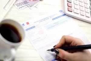 KYIV, UKRAINE - OCTOBER 31, 2023 Accountant fill french tax form 10963 Value added tax and similar taxes in end of tax period. Taxation and paperwork routine photo