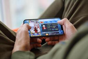 Fate Grand Order mobile iOS game on iPhone 15 smartphone screen in male hands during mobile gameplay photo