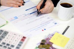 KYIV, UKRAINE - OCTOBER 31, 2023 Accountant fill french tax form CA12 Value added tax and similar taxes in end of tax period. Taxation and paperwork routine photo
