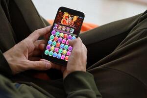 Puzzle and dragons mobile iOS game on iPhone 15 smartphone screen in male hands during mobile gameplay photo