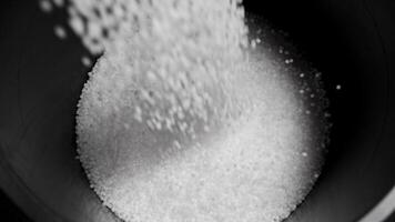 Filling the tank with plastic granules. The process of producing parts from polyethylene compound. White granules are poured into a container. video