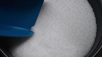 Checking the quality of a polymer composite in production using a scoop. White plastic granules in a special container. Technology for the production video