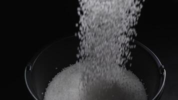 Filling the tank with plastic granules. The process of producing parts from polyethylene compound. White granules are poured into a container. video