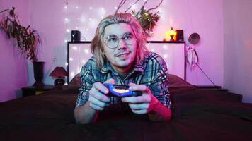 Man is playing a game when he loses. This makes him upset and he throws the joystick away. video