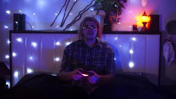 Man is playing a game on a console in his room, in the evening. The police are chasing him in the virtual world of the game. video