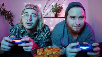 Two guys are enjoying playing a game on a console while lying on the bed. video