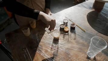 Process of mixing epoxy paint to find the perfect shade of white. Close up. Slow motion video