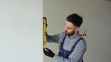 Turkish engineer builder measures of the vertical deviation of the wall. Bubble level ruler close up view, measuring and leveling concept video