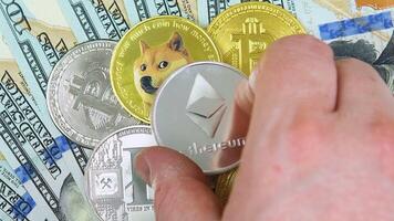 A hand putting an Ethereum coin on a pile of different cryptocurrency coins. Digital coin cyberspace and cryptocurrency video