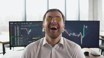 Excited miner, trader or broker posing with golden bitcoins in eyes video
