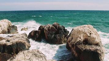 Serene Dancing. Rocks Balancing on Turquoise Waves Watch as a group of rocks delicately balance atop the shimmering turquoise waves, gently swaying with each crash of the sea. video
