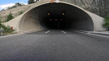First person view car entering tunnel in mountains. drive begins as car approaches tunnel, showcasing transition from open road to tunnel. mountain drive emphasizes the engineering marvel video