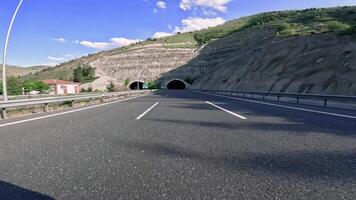 First person view car entering a tunnel in the mountains. tunnel offers a brief glimpse of the mountain's interior. The drive through the tunnel emphasizes engineering marvel of mountain tunnels video