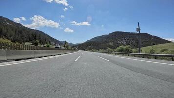 Driving on a winding road with lush forests and towering mountains in the backdrop, the vast expanse of nature unfolds in breathtaking vistas video