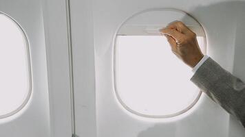 Two businessman passengers sitting in airplane cabin and working on laptop together. Businessman in brown suit showing project on notebook to businessman with eyeglasses. Business and travel concept. video