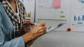 Financial analysts analyze business financial reports on a digital tablet planning investment project during a discussion at a meeting of corporate showing the results of their successful teamwork. video