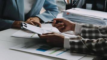 Financial analysts analyze business financial reports on a digital tablet planning investment project during a discussion at a meeting of corporate showing the results of their successful teamwork. video