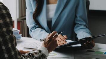 Financial analysts analyze business financial reports on a digital tablet planning investment project during a discussion at a meeting of corporate showing the results of their successful teamwork. video