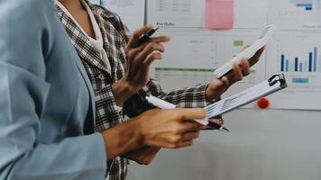 Financial analysts analyze business financial reports on a digital tablet planning investment project during a discussion at a meeting of corporate showing the results of their successful teamwork. video
