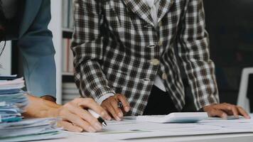 Close up Business woman using calculator and laptop for do math finance on wooden desk in office and business working background, tax, accounting, statistics and analytic research concept video