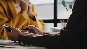 Financial analysts analyze business financial reports on a digital tablet planning investment project during a discussion at a meeting of corporate showing the results of their successful teamwork. video
