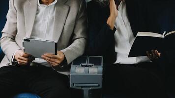 Two businessman passengers sitting in airplane cabin and working on laptop together. Businessman in brown suit showing project on notebook to businessman with eyeglasses. Business and travel concept. video