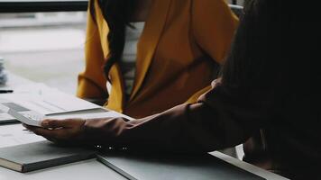 Financial analysts analyze business financial reports on a digital tablet planning investment project during a discussion at a meeting of corporate showing the results of their successful teamwork. video