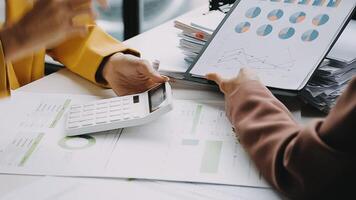 Financial analysts analyze business financial reports on a digital tablet planning investment project during a discussion at a meeting of corporate showing the results of their successful teamwork. video