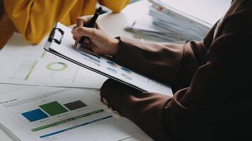 Financial analysts analyze business financial reports on a digital tablet planning investment project during a discussion at a meeting of corporate showing the results of their successful teamwork. video