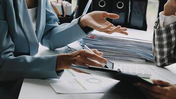 Financial analysts analyze business financial reports on a digital tablet planning investment project during a discussion at a meeting of corporate showing the results of their successful teamwork. video