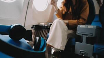 A successful asian businesswoman or female entrepreneur in formal suit in a plane sits in a business class seat and uses a documents with computer laptop during flight video