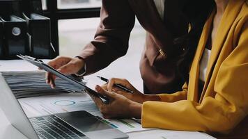 Financial analysts analyze business financial reports on a digital tablet planning investment project during a discussion at a meeting of corporate showing the results of their successful teamwork. video