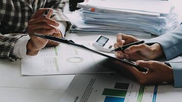 Financial analysts analyze business financial reports on a digital tablet planning investment project during a discussion at a meeting of corporate showing the results of their successful teamwork. video