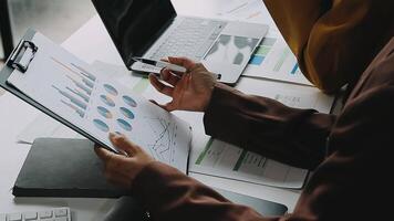 Financial analysts analyze business financial reports on a digital tablet planning investment project during a discussion at a meeting of corporate showing the results of their successful teamwork. video