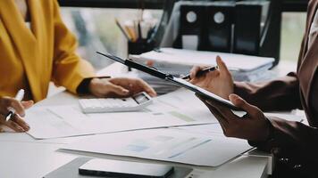Financial analysts analyze business financial reports on a digital tablet planning investment project during a discussion at a meeting of corporate showing the results of their successful teamwork. video