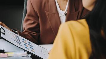 Financial analysts analyze business financial reports on a digital tablet planning investment project during a discussion at a meeting of corporate showing the results of their successful teamwork. video
