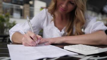 Woman working with documents in a summer cafe slow motion 4k video