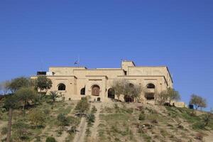 Saddam palace on hill in Babylon with blue sky photo