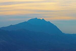 mountain peak in the shape of human face looking up at the sky in northern iraq with cloudy sky photo
