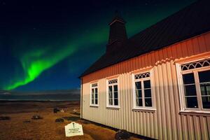 Islandia - marzo 20, 2023 - strandarkirkja protestante Iglesia con tumba a noche con claro cielo y Aurora boreal. famoso Aurora borealis del Norte luces persiguiendo caza excursión ubicaciones foto